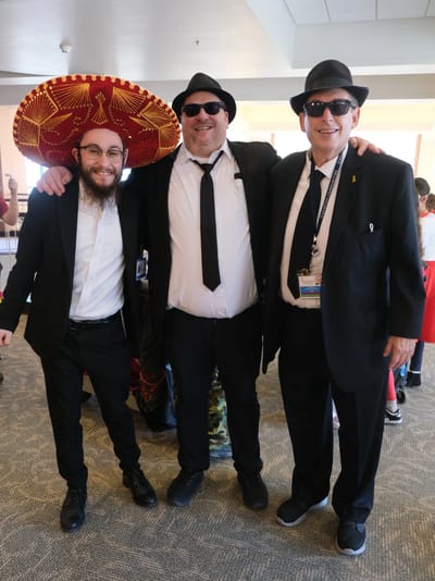Three staff members celebrating in festive attire