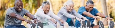 Residents participating in a group stretching activity outdoors