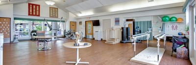 Therapy room with exercise equipment and wooden floors