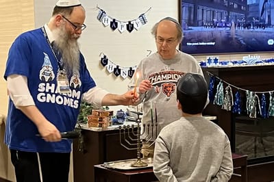 Residents celebrating Hanukkah with a menorah