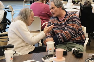 Two residents engaged in conversation in a common area