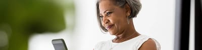 Senior woman using a smartphone with a soft background