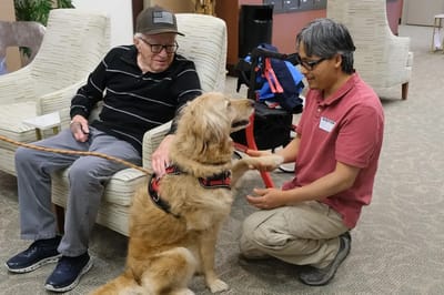 Resident interacting with a therapy dog in a common area