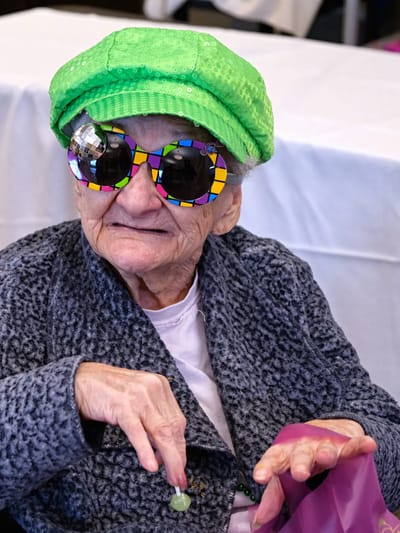 Resident wearing colorful sunglasses and a green hat