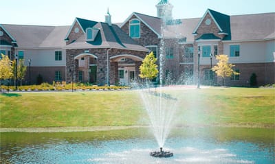 Exterior view of a senior living facility with a fountain