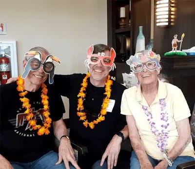 Residents and staff wearing fun glasses during a celebration