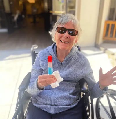 Resident enjoying a popsicle in a facility wheelchair