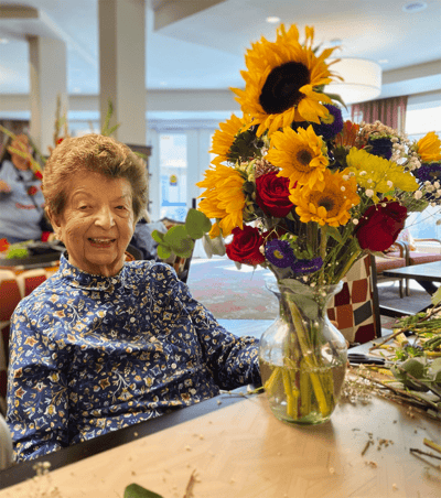 Resident creating a floral arrangement in a common area
