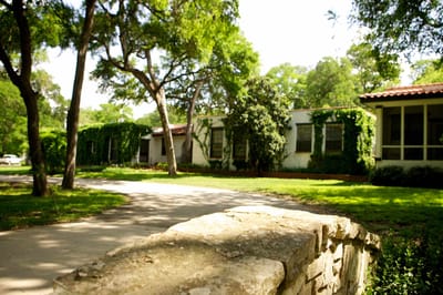 Exterior view of The Lodge at Leon Springs with greenery.