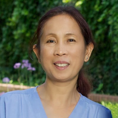 Staff member smiling outdoors in natural light.