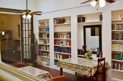 Cozy reading area with bookshelves and floral tablecloth.