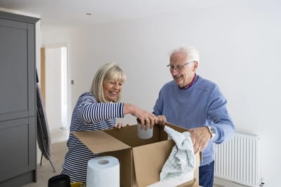 Senior couple packing a box together.