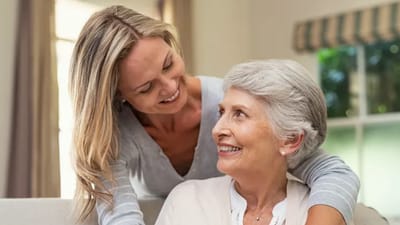 Caregiver smiling with senior resident indoors