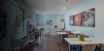 Bright activity room with tables and artwork.