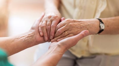 Two hands together showcasing care and support.