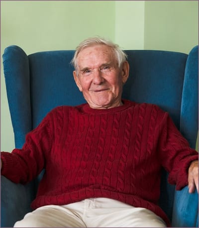Smiling elderly man in a cozy chair