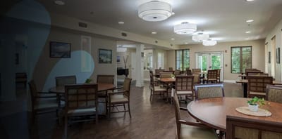 Bright common area with dining tables and chairs.