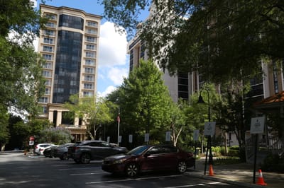 Exterior view of Renaissance on Peachtree with trees and parking