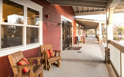 Outdoor walkway with wooden chairs and landscaping