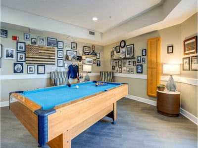 Billiards table in a cozy common area with framed photos