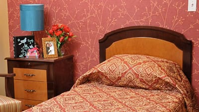 Cozy resident room with floral decor and bedside table