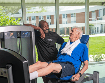 A resident and staff member engaged in fitness activity