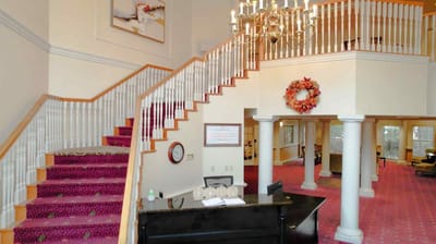 Welcoming entrance area with stairs and floral decor.