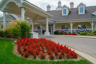 Beautiful exterior with red flowers and welcoming entrance.