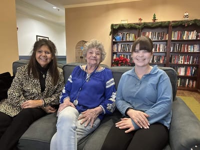 Residents and staff sitting together smiling