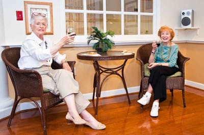 Two residents enjoying drinks in a common area.