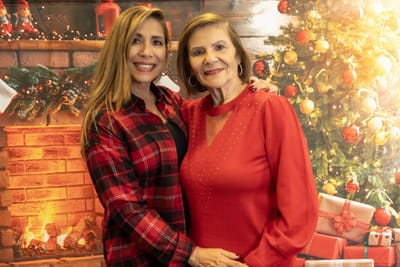 Two women pose together in a festive setting.