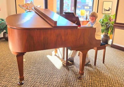 Resident playing piano in a common area