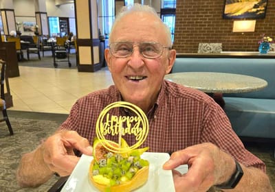 Resident celebrating birthday with a dessert.