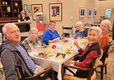 Residents enjoying a meal together at a dining table.