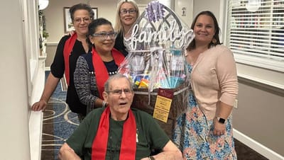 Residents and staff celebrating with a gift basket.