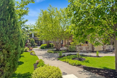 Lush outdoor pathway with greenery and seating areas.