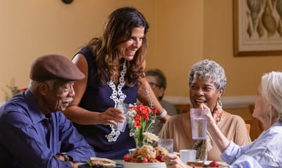 Residents and staff enjoying a meal together