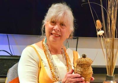 Senior resident holding a decorative item in a common area.