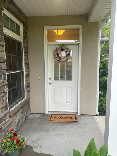 Entrance of a facility with a welcome mat and flowers