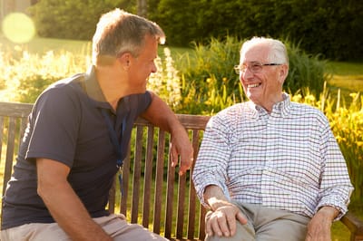 A caregiver chatting with a senior resident outdoors