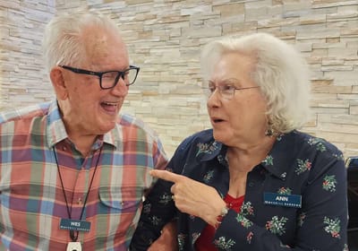 Two residents sharing a joyful conversation indoors.