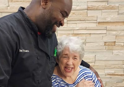 Chef interacting joyfully with a senior resident
