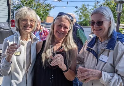 Three women enjoying a celebration with drinks.