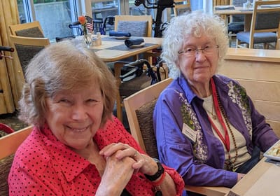 Two smiling residents enjoying a meal together