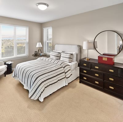 Cozy bedroom with a striped bedspread and natural light.