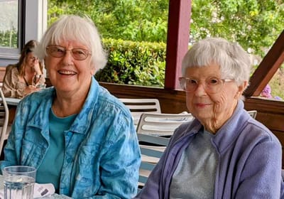 Two elderly women enjoying time together outdoors.