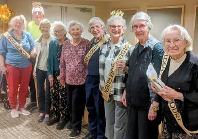 Residents celebrating with sashes at an event.