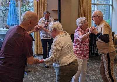 Seniors dancing together in a common area