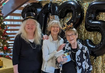 Three residents celebrating together with festive decorations.
