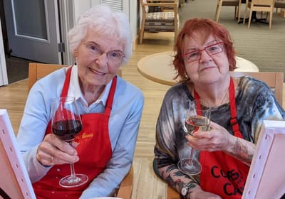 Two residents enjoying drinks during an activity.
